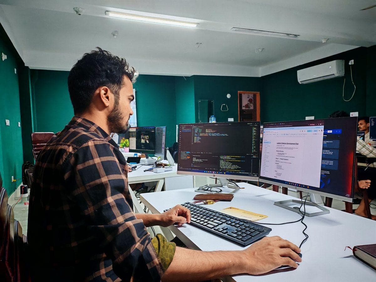 Entwickler an Multi-Monitor-Setup mit Code